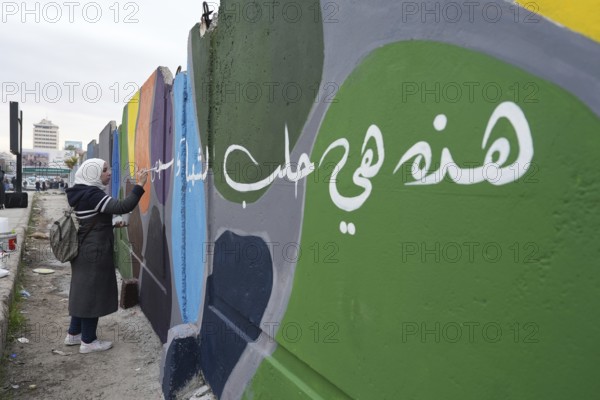 Young volunteers paint murals on walls to decorate the city following the fall of Bashar al-Assad's regime. Aleppo, Syria. December 21, 2024, Aleppo, Aleppo, Syria