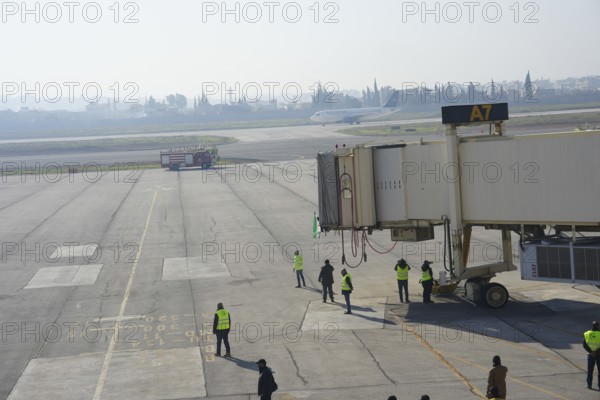 Syrians gather to welcome the first passenger plane to land at Aleppo International Airport following the fall of Bashar al-Assad's regime. Aleppo, Syria. December 18, 2024, Aleppo, Aleppo, Syria