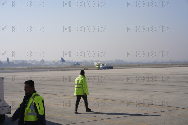 Passengers celebrate with Syrian revolutionary flags as the first flight lands at Aleppo International Airport in the presence of government officials following the fall of Bashar al-Assad's regime. Aleppo, Syria. December 18, 2024, Aleppo, Aleppo, Syria