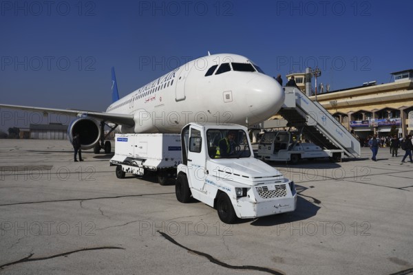 Passengers celebrate with Syrian revolutionary flags as the first flight lands at Aleppo International Airport in the presence of government officials following the fall of Bashar al-Assad's regime. Aleppo, Syria. December 18, 2024, Aleppo, Aleppo, Syria