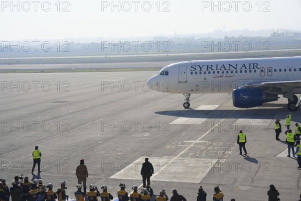 Syrians gather to welcome the first passenger plane to land at Aleppo International Airport following the fall of Bashar al-Assad's regime. Aleppo, Syria. December 18, 2024, Aleppo, Aleppo, Syria