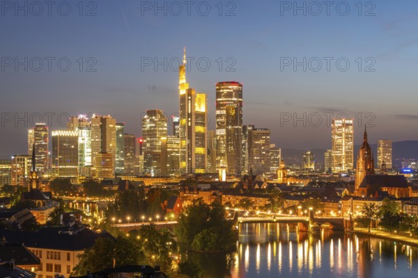 Illuminated Frankfurt Downtown Skyscrapers, Residential Buildings, Bridges and Main River at Night. Aerial View. Blue Hour. Hesse, Germany