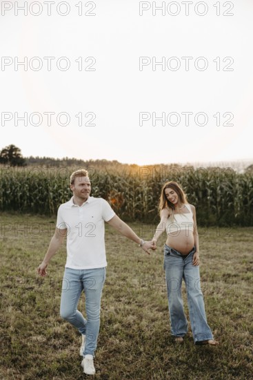 Pregnant young woman walks with her partner