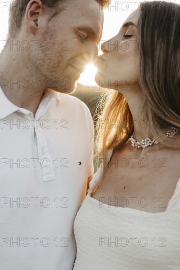 Young couple in love kissing in front of the sunset