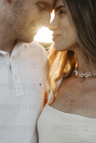 Young couple in love, forehead to forehead in front of the sunset