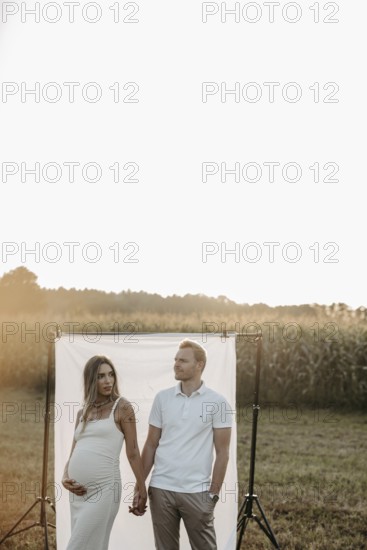 Pregnant young woman with partner at a baby bump shoot