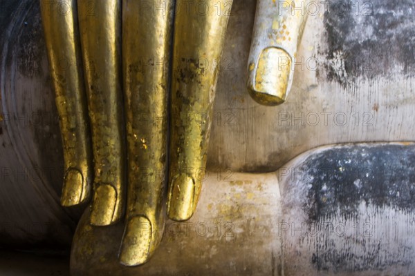 Golden Buddha finger in the temple Wat Si Chum in Sukhothai