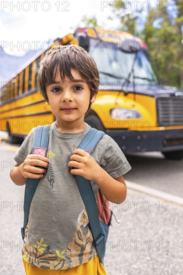 Preschool student carrying backpack and waiting for school bus, excited for first day of class, symbolizing back to school season and childhood education