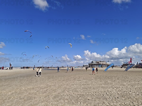 California kitesurfing Masters 2025 on the edge of the Wadden Sea UNESCO World Heritage Site, North Sea, beach, kitesurfing, sport, leisure, pile dwelling, summer, sun, blue sky, white clouds, Ording, Sankt Peter-Ording, Schleswig-Holstein, Germany