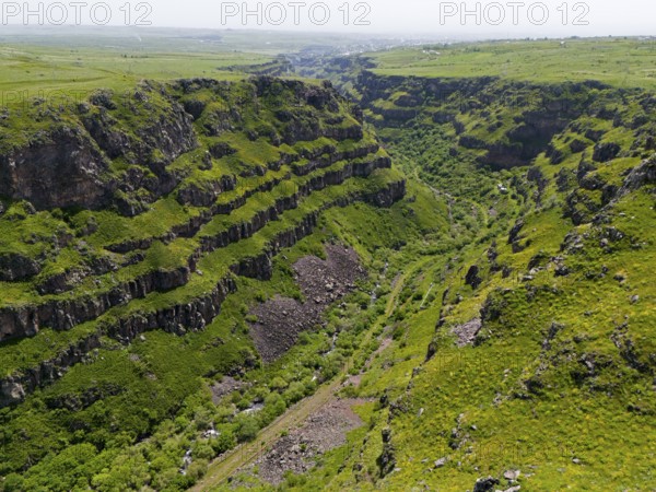 Deep gorge with lush green vegetation between steep rocks under a wide sky, aerial view, Kassagh gorge near Saghmosavank monastery, Saghmosavank, Saghmosavank, Salmosavank, Aragazotn province, Armenia