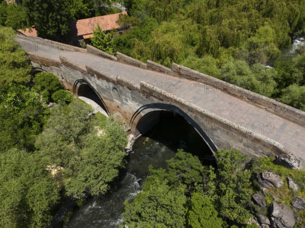 Stone bridge with arches over a river, surrounded by lush trees and nature, aerial view, Three-arch bridge over the Kassagh River from 1664, Ashtarak Bridge, Ashtarak, Aštarak, Aragazotn Province, Armenia