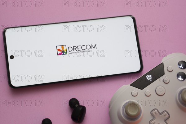 Dhaka, Bangladesh- 13 Sep 2025: A close-up of a gamepad with the Drecom seen on smartphone