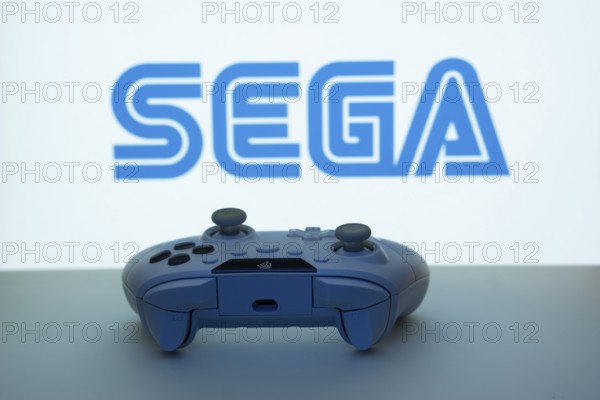 Dhaka, Bangladesh- 13 Sep 2025: A close-up of a white gamepad with the Sega seen on screen in the background
