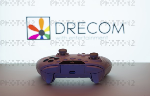 Dhaka, Bangladesh- 13 Sep 2025: A close-up of a white gamepad with the Drecom seen on screen in the background