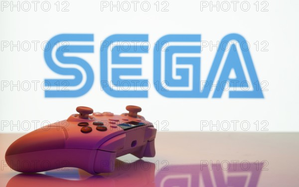 Dhaka, Bangladesh- 13 Sep 2025: A close-up of a white gamepad with the Sega seen on screen in the background