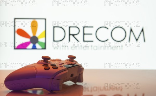 Dhaka, Bangladesh- 13 Sep 2025: A close-up of a white gamepad with the Drecom seen on screen in the background