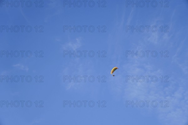 Paragliding on a sunny day with cirrus clouds, enjoying freedom and adventure in ronda, malaga, spain