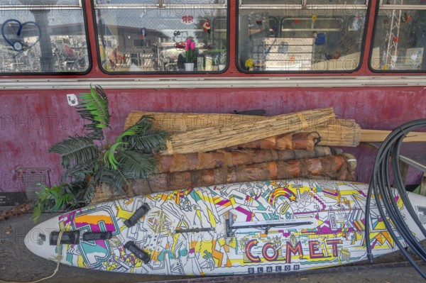 A rail bus from the 1950s is being renovated at the Spatz youth centre, with a pop-painted surfboard in front of it, Kisslegg, Allgäu, Baden-Württemberg, Germany