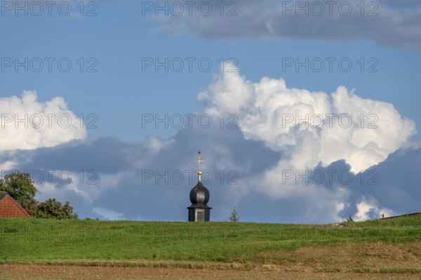 Tower of a chapel behind a meadow hill, cloudy sky, Köttweinsdorf, Upper Franconia, Bavaria, Germany