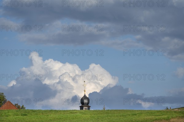 Tower of a chapel behind a meadow hill, cloudy sky, Köttweinsdorf, Upper Franconia, Bavaria, Germany