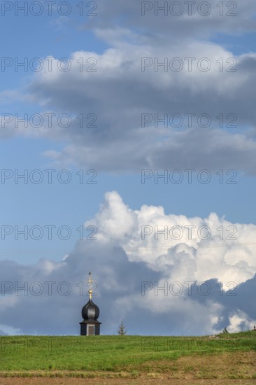 Tower of a chapel behind a meadow hill, cloudy sky, Köttweinsdorf, Upper Franconia, Bavaria, Germany