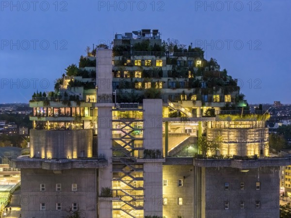 Aerial view of the Hamburg bunker on Heiligengeistfeld during the blue hour with illuminated floors and green trees at night, Hamburg, Germany