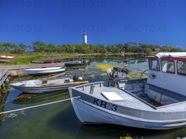 Long Erik lighthouse, Long Erik, on the northern tip of the Swedish island of Stora grundet in the Baltic Sea, wooden boats at the jetty, Stora grundet, Öland, Sweden
