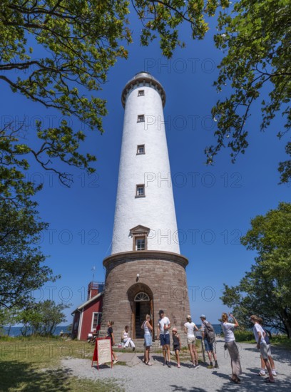 Tourists stand in front of the Lange Erik lighthouse, Langer Erik, on the northern tip of the Swedish Baltic Sea island of Stora grundet, Öland, Sweden
