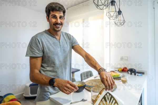 Happy man preparing a nutritious breakfast in a bright, modern kitchen, enjoying a relaxed morning routine filled with healthy choices