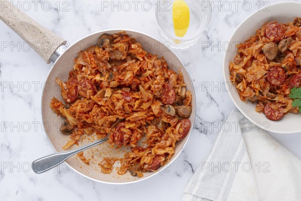 Bigos, Polish dish bigos, on the table, pan with stewed meat, with cabbage, chorizo sausages, mushrooms, homemade, without people