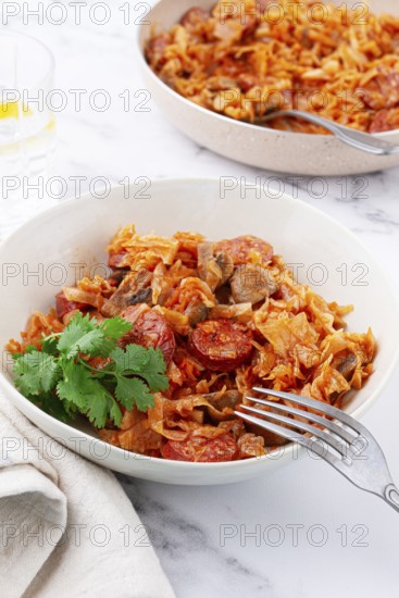 Bigos, Polish dish bigos, on the table, pan with stewed meat, with cabbage, chorizo sausages, mushrooms, homemade, without people