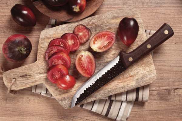 Sliced tomatoes, Black Beauty variety, on a cutting board, top view, on the kitchen table