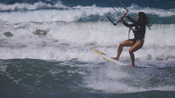 Woman kitesurfing sportily over the waves under a clear sky, Prasonisi, beach, surf, windsurfer, kite surfer, waves, south coast, Rhodes, Dodecanese, Greek Islands, Greece
