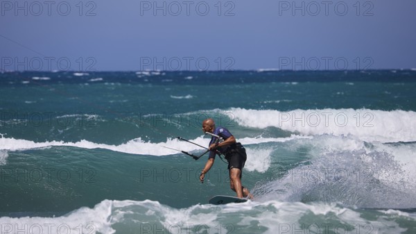 Kitesurfer gliding over the waves in sunny weather and blue sky, Prasonisi, beach, surf, windsurfer, kite surfer, waves, south coast, Rhodes, Dodecanese, Greek Islands, Greece