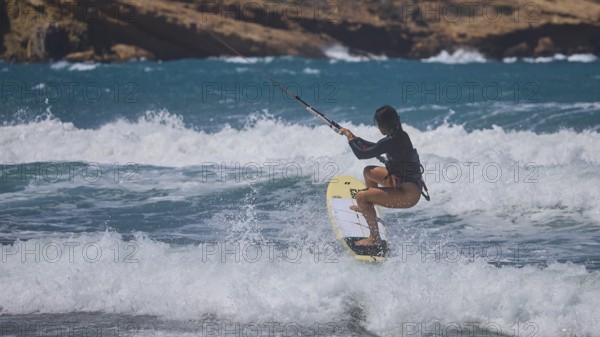 Kitesurfer spraying over waves in the blue sea, rocky coast in the background, Prasonisi, beach, surf, windsurfer, kite surfer, waves, south coast, Rhodes, Dodecanese, Greek Islands, Greece