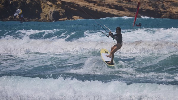 Kitesurfer skilfully navigates the waves off the rocky coast, Prasonisi, beach, surf, windsurfer, kite surfer, waves, south coast, Rhodes, Dodecanese, Greek Islands, Greece
