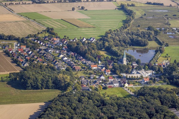 Aerial view, St Christophorus parish church, Woestegraben pond, F. Schumacher Maschinenbauunternehmen, Ostinghausen, Bad Sassendorf, Kreis Soest, North Rhine-Westphalia, Germany, place of worship, DE, Europe, commercial enterprises, commercial area, commercial location, commercial use, religious community, place of worship, industrial area, industrial location, church, parish, Kirchstraße, denomination, Kreis-Soest-Buch, KreisSoestBuch, landscape conservation area Woeste, aerial photograph, aerial photography, aerial photography, religion, pond, overview, bird's-eye view, birds-eyes view, overview