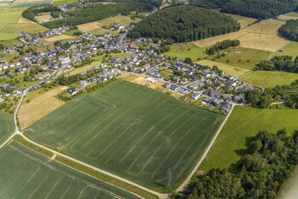 Aerial view, local view district Beckum, building area new construction single-family houses, catholic church St. Nikolaus, Balve, Sauerland, North Rhine-Westphalia, Germany, place of worship, DE, Europe, religious community, place of worship, property tax, real estate, church, parish, denomination, aerial view, aerial photography, aerial photography, Roussayer Weg, overview, bird's-eye view, wooded area, meadows and fields, living and life, residential area, residential buildings, quality of life, housing estate, Zum Langenloh, birds-eyes view, overview