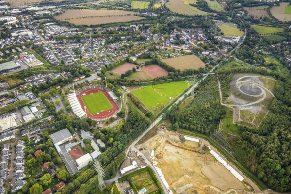 Aerial view, Lohrheide stadium, Rheinelbe slag heap, Wattenscheider Bach rainwater retention basin construction site, former Rhenish railway road, RS1 cycle highway, Leithe, Bochum, Ruhr area, North Rhine-Westphalia, Germany, railway line, construction work, construction area, construction measure, construction project, mining, slag heap, Bochum-Wattenscheid, DE, Europe, football pitch, football stadium, football club, Gelsenkirchen, slag heap, Himmelstreppe, Hollandstraße, landmark, landscape forms, landscape park, Leithestraße, Lohrheide, aerial view, aerial photography, aerial photography, Olympic training centre Ruhr-Ost, RS1, Route of Industrial Heritage, pointed cone, sport, sports facilities, sports field, sports field Espenloh, sports facility, stadium, Wattenscheid district, Tafelberg, Rheinische Bahn road, overview, bird's-eye view, Wattenscheid, birds-eyes view, former railway line, former Rheinelbe colliery, overview