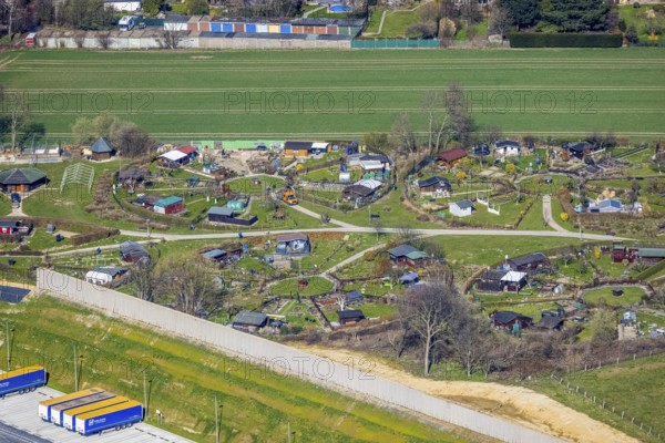 Aerial view, allotment garden site Mellmausland next to the Amazon site on the industrial estate on Brauckstraße, Rüdinghausen, Witten, Ruhr area, North Rhine-Westphalia, Germany, DE, Europe, community garden, allotment garden, allotment garden site, allotment garden association, aerial view, aerial photography, aerial photography, Menglinghauser Straße, allotment garden, overview, bird's-eye view, overview, shadow of the noise barrier, construction of a noise barrier