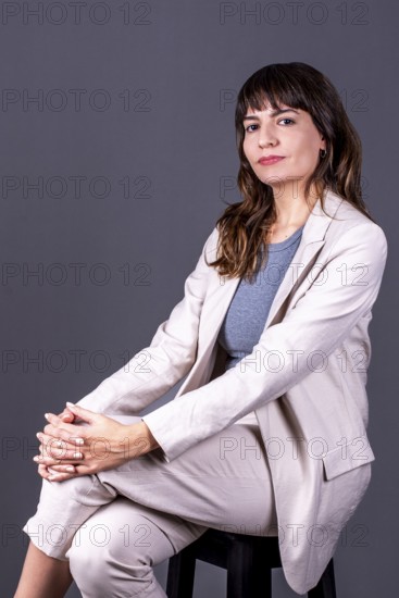 Elegant young businesswoman sitting and looking at the camera
