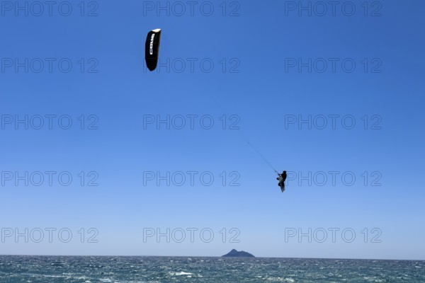 Kitesurfer kite surfer makes big high giant jump with kite kite sail over sea surface, international