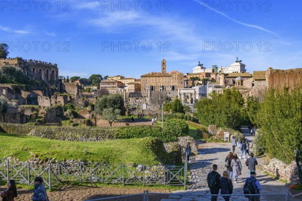 View to the right Via Sacra, to the left at the edge of the picture foot of Palatine Hill Palatine Hill in front of it ruins of ancient residential buildings tenement houses Domus Insulae, in the background in the centre Tabularium on Capitoline Hill with Campanile from the Middle Ages, to the right of it white upper terrace of national monument of Victor Emmanuel II Vittoriano with bronze sculptures Quadriga of Unity and Quadriga of Victory, Forum Romanum, Rome, Latium, Italy
