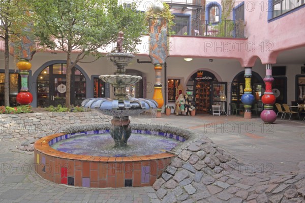 Inner courtyard with fountain and colourful columns, Green Citadel, Hundertwasser House, Magdeburg, Saxony-Anhalt, Germany