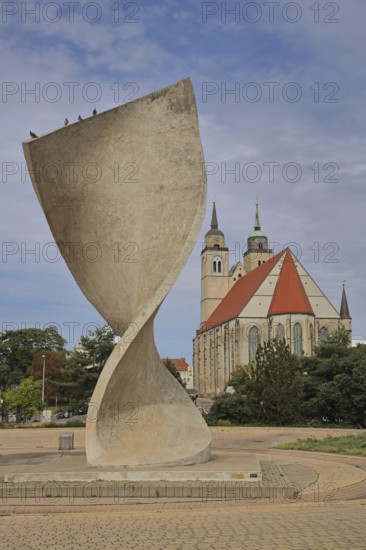 Sculpture Flag monument by Joachim Sendler 1974, late Romanesque St. Johannis Church, concrete, modern art, abstract art, large sculpture, curved, bent, arched, curved, spiral, helix, twisted, turned, Elbuferpromenade, Magdeburg, Saxony-Anhalt, Germany