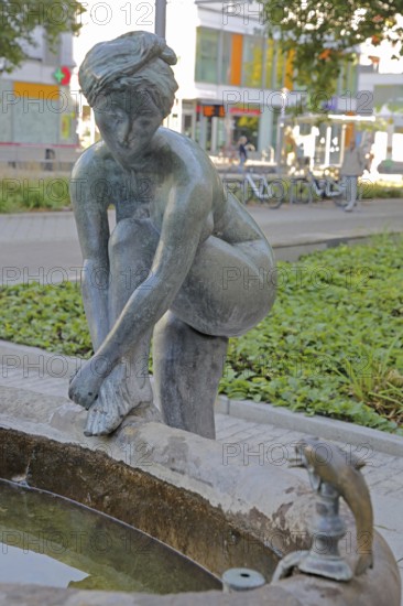 Sculpture Bathing Girl by Heinrich Apel 1972, bronze sculpture, modern art, bathing female figure with one leg on water basin above, looking, looking, watching, dolphin figure, Magdeburg, Saxony-Anhalt, Germany