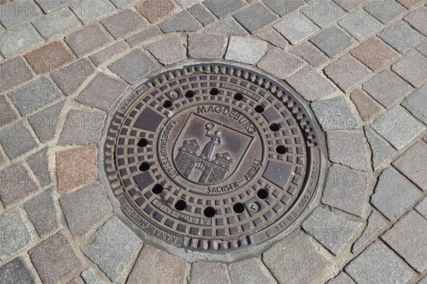 Manhole cover with city coat of arms, paving stones, floor, inscription, Magdeburg, Saxony-Anhalt, Germany