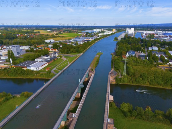 A panoramic view shows a canal with bridges and surrounding city and industrial buildings as well as green areas, waterway junction, Mittellandkanal over Weser, trough bridge, Minden, North Rhine-Westphalia, Germany