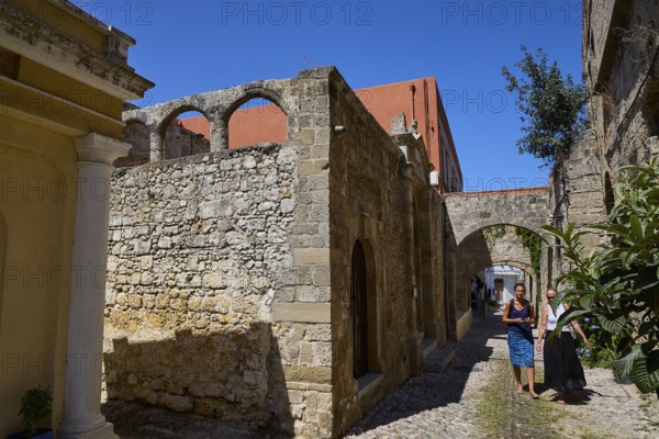 Narrow alley in an old town with two people and old buildings, Kahal Shalom Synagogue, Sephardic Synagogue, Oldest Synagogue in Greece, Synagogue, Jewish Quarter, Old Town Rhodes, Rhodes Town, Rhodes, Dodecanese, Greek Islands, Greece
