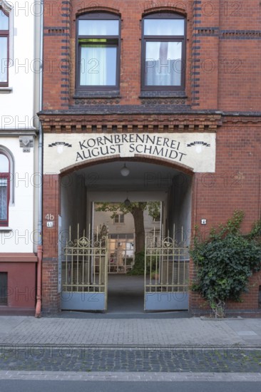 Photograph of the entrance to an old grain distillery with a wrought-iron golden Tor tor, Hainholz, Hanover, Lower Saxony, Germany